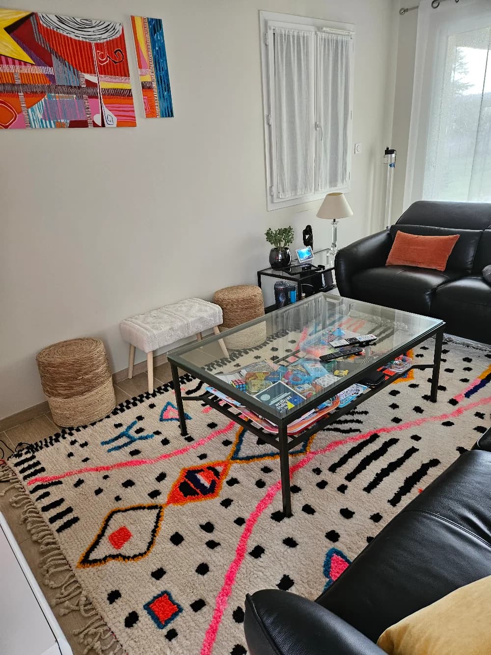 Tapis berbère coloré installé sous une table basse dans un salon