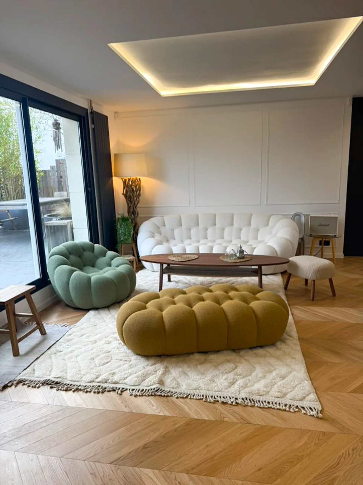 Tapis berbère écru dans un salon aux fauteuils colorés