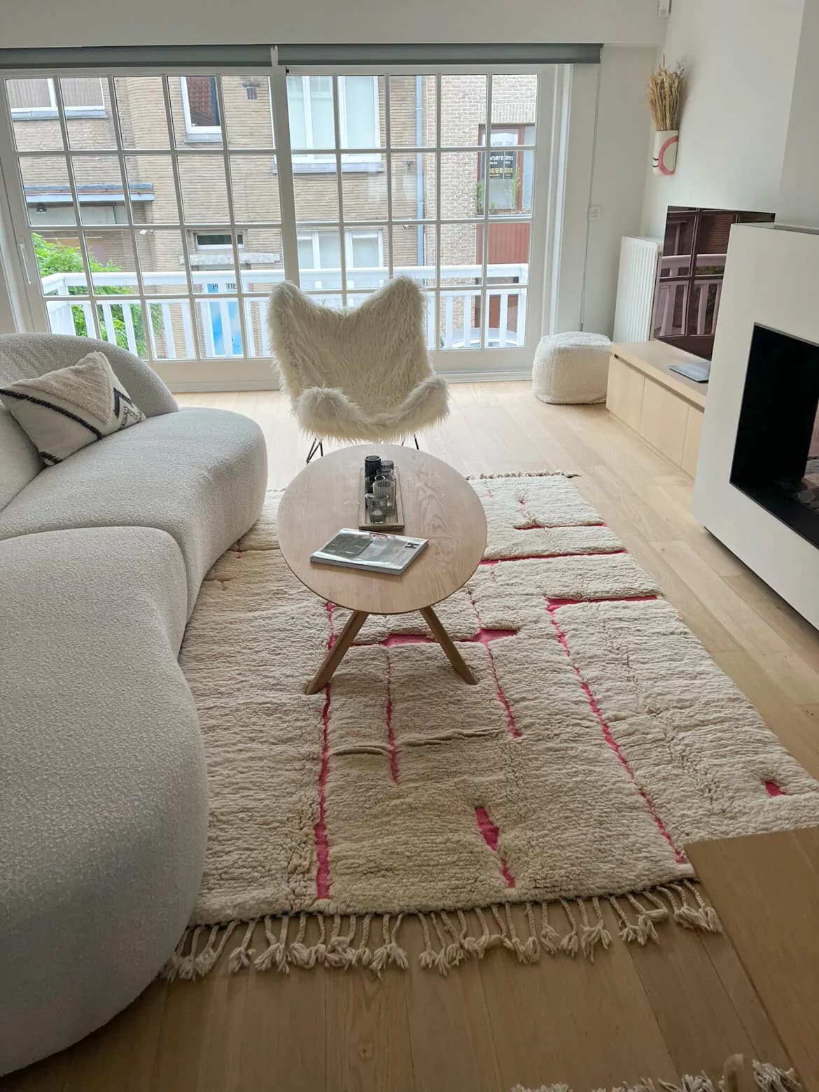 Tapis berbère écru aux lignes roses dans un salon lumineux