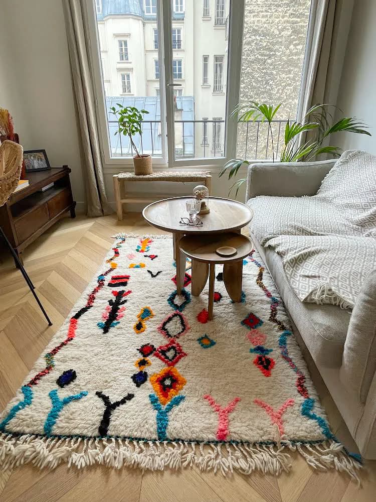 Tapis berbère multicolore dans un salon lumineux près d’une fenêtre