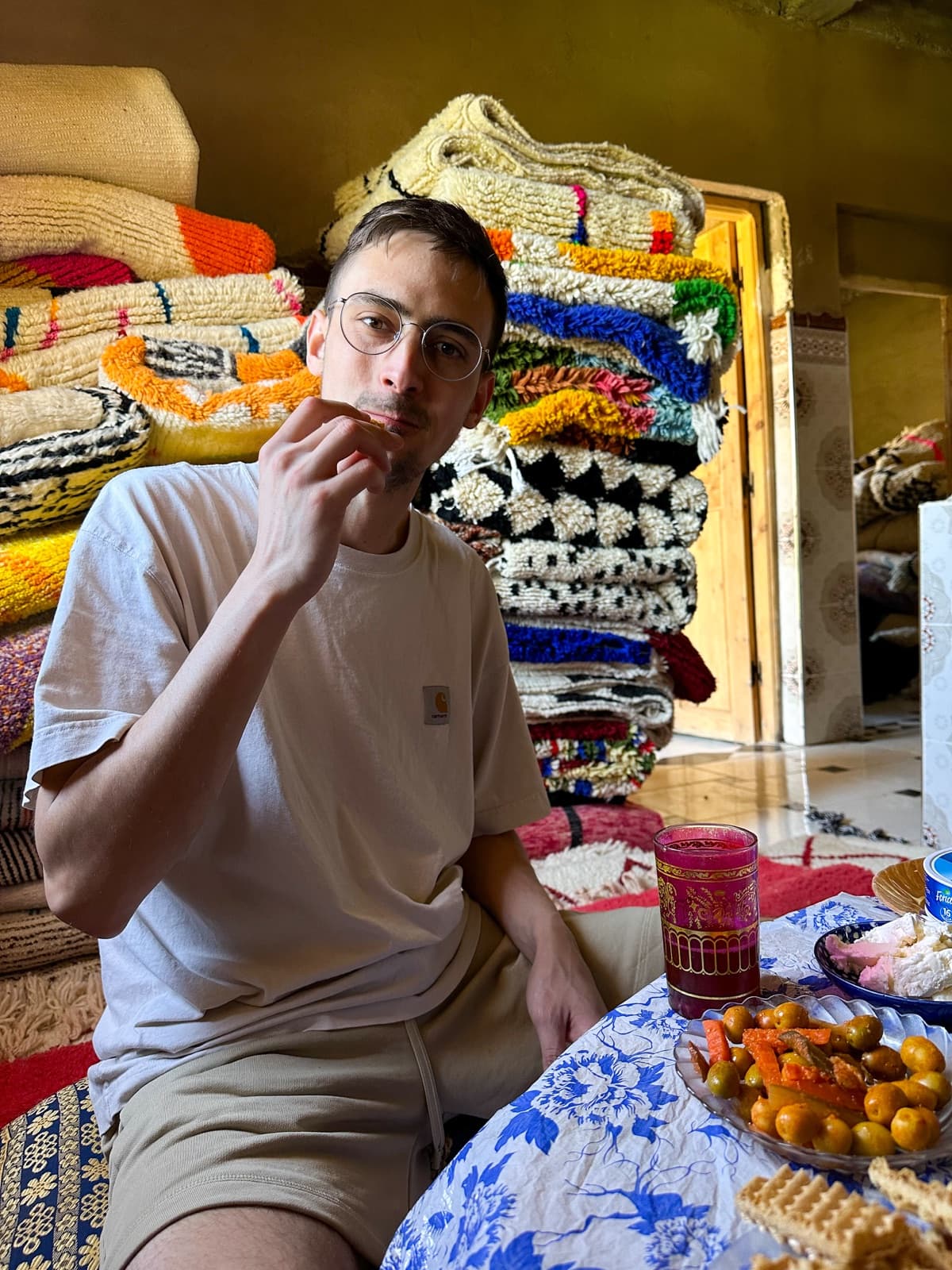 Kevin au Maroc, entouré de tapis berbères