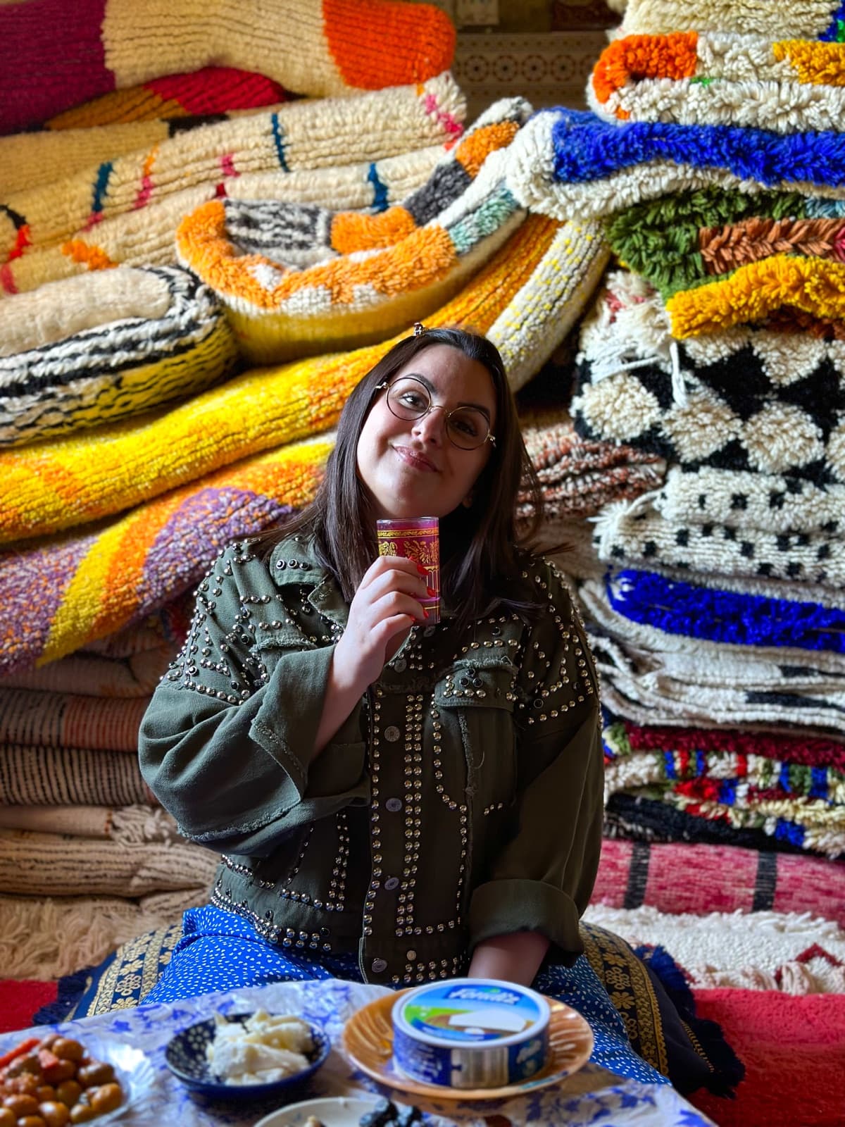 Prescillia au Maroc, entourée de tapis berbères